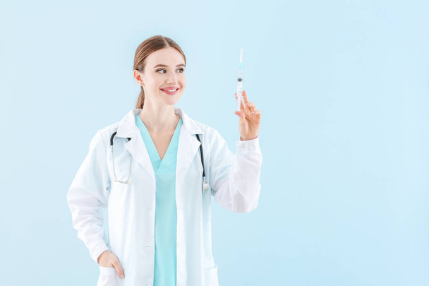 Retrato de doctora con jeringa sobre fondo claro - Foto, Imagen