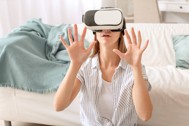 Jeune femme avec des lunettes de réalité virtuelle à la maison - Photo, image