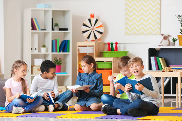 Милые маленькие дети читают книги в помещении
 - Фото, изображение