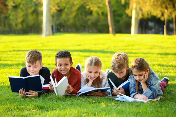 Cute little children reading books in park - Photo, Image