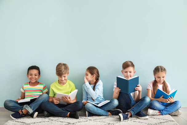 Aranyos kis gyerekek könyvet olvasott színes háttér - Fotó, kép