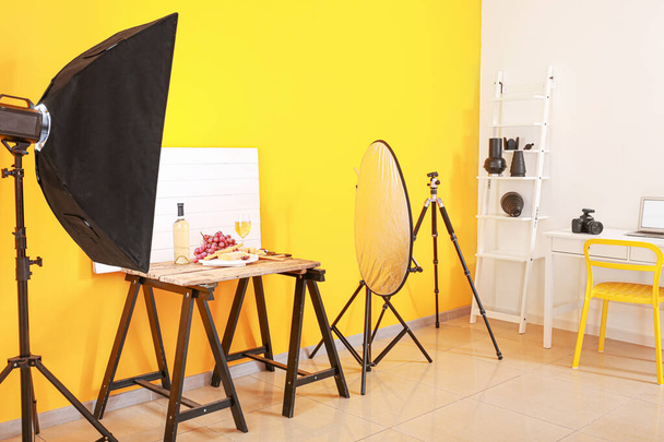 Interior del moderno estudio fotográfico con equipo profesional y comida en la mesa
 - Foto, Imagen