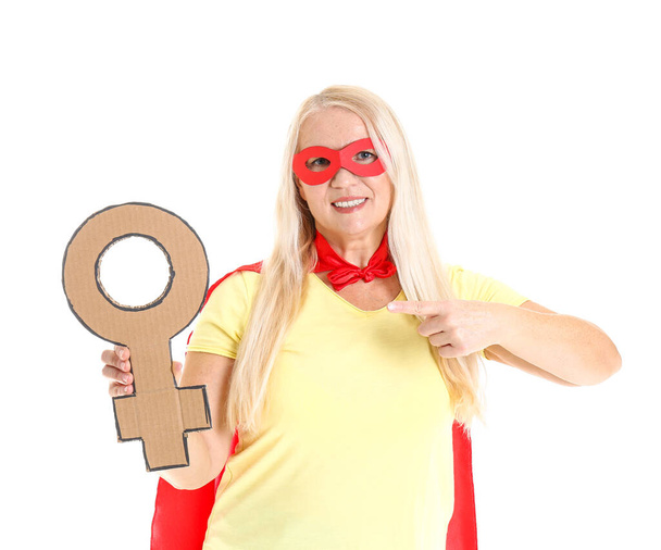 Dáma v kostýmu superhrdiny se symbolem ženy na bílém pozadí. Koncept feminismu - Fotografie, Obrázek