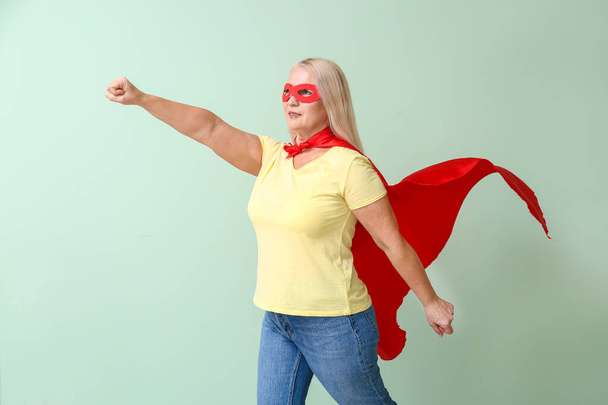 色の背景にスーパーヒーローの衣装の女性。フェミニズムの概念 - 写真・画像