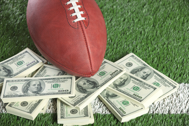 NFL football on field with a pile of money - Foto, afbeelding