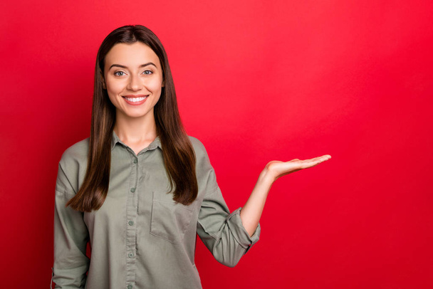 Portrait of her she nice-looking attractive confident cheerful straight-haired girl holding invisible object on palm gift present surprise isolated over bright vivid shine vibrant red color background - Φωτογραφία, εικόνα