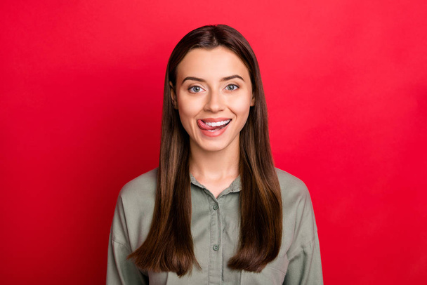 Close-up portrait of her she nice attractive lovely cheerful cheery straight-haired girl wearing khaki shirt licking lips flirting isolated over bright vivid shine vibrant red color background - Foto, Bild