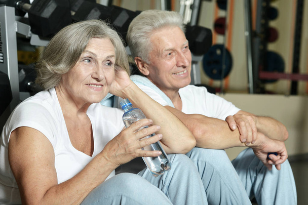Senior couple drinking in gym - Zdjęcie, obraz