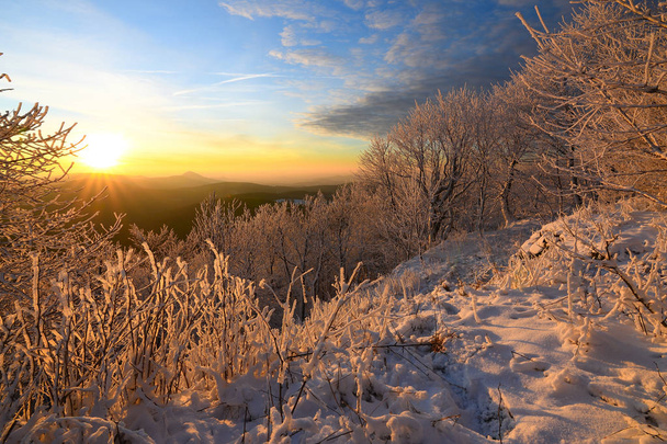 Pintoresca cresta colorida de la salida del sol contra las colinas brumosas azules
 - Foto, Imagen