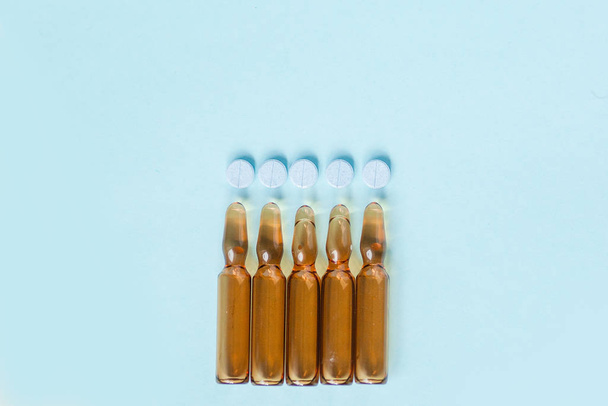 pills and medicine in a bottle on a blue background - Φωτογραφία, εικόνα