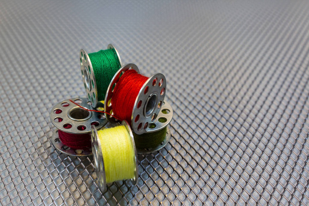 Bobine di filati di una macchina per cucire con diversi colori di filati
 - Foto, immagini