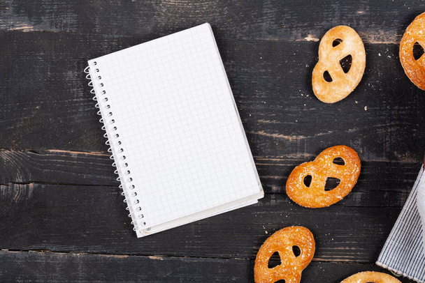Notebook on a background of sweet cookies counting calories - Foto, afbeelding