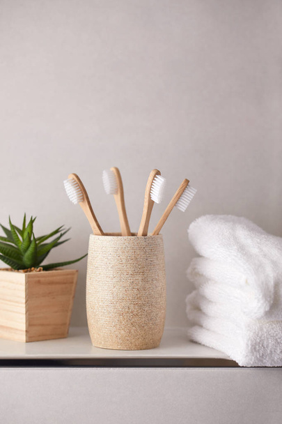 Ecological bamboo toothbrushes with white towels in bathroom - Zdjęcie, obraz