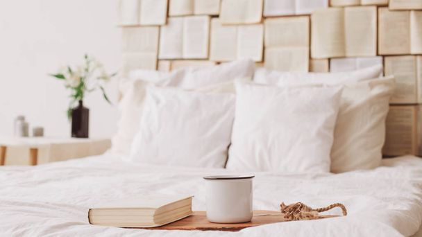 Spring still life. Breakfast in bed. White bedroom. Sweet home. Books and coffee cup. flat lay - 写真・画像