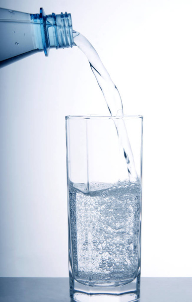 glass of water in a transparent container - Φωτογραφία, εικόνα