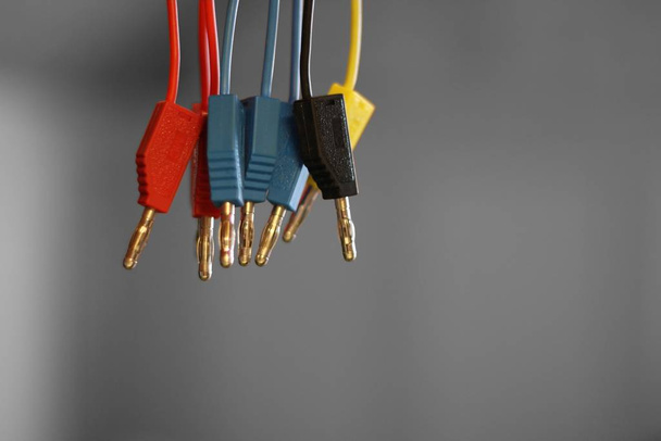 A closeup shot of colorful wires on a grey background - Foto, Imagem