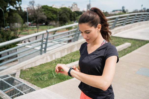 Fitness woman checking time on smart watch. - Zdjęcie, obraz