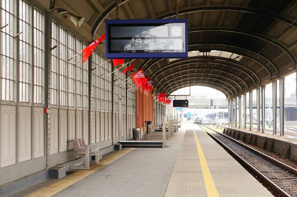 POZNAN, POLONIA - 13 de enero de 2020: Plataforma de la estación de tren oeste con banderas rojas en el centro de la ciudad
. - Foto, imagen