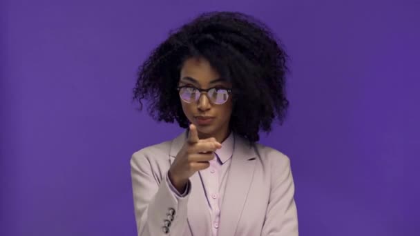 african american businesswoman pointing with finger and smiling isolated on purple  - Кадри, відео