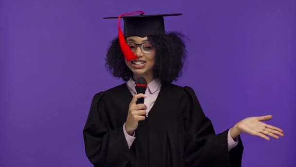 χαμογελαστός Αφροαμερικάνος απόφοιτος μιλώντας απομονωμένος στο μωβ  - Πλάνα, βίντεο