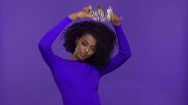 mujer afroamericana bailando con corona aislada sobre púrpura
  - Imágenes, Vídeo