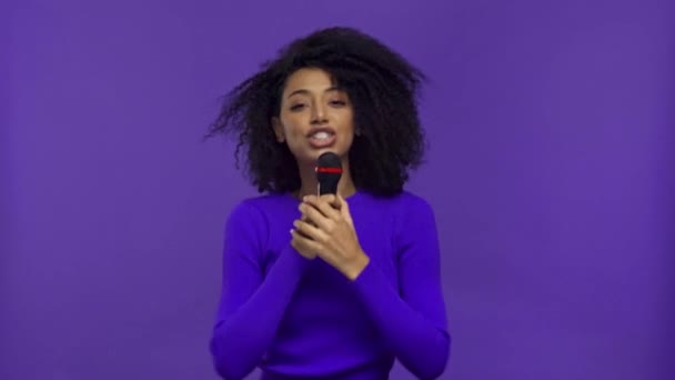 sorridente afro-americana cantando isolado em roxo
  - Filmagem, Vídeo