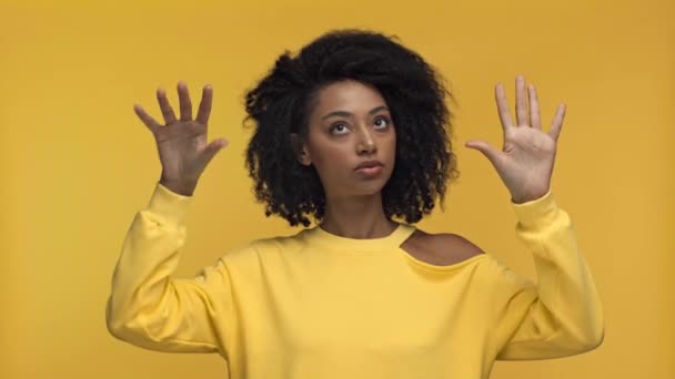 africká americká žena ukazuje skleněné gesto izolované na žluté - Záběry, video