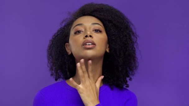 mujer afroamericana posando y sonriendo aislada en púrpura
  - Metraje, vídeo