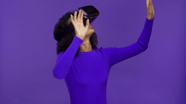 curious african american woman in vr headset isolated on purple  - Footage, Video