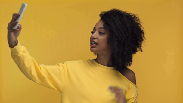 улыбающаяся африканская американка с видеозвонком, изолированным на желтом
 - Кадры, видео