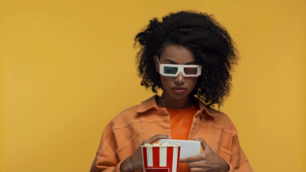 Aufgeregt afrikanisch-amerikanische Frau macht Foto im Kino isoliert auf gelb - Filmmaterial, Video