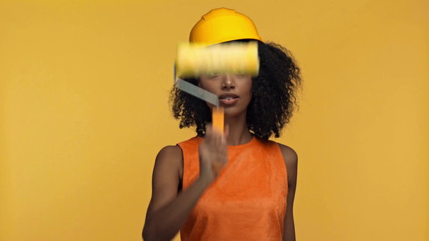 mosolygós afro-amerikai festő segítségével festék görgő izolált sárga - Felvétel, videó