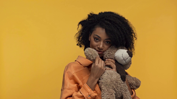 smiling african american woman holding teddy bear isolated on yellow  - Footage, Video