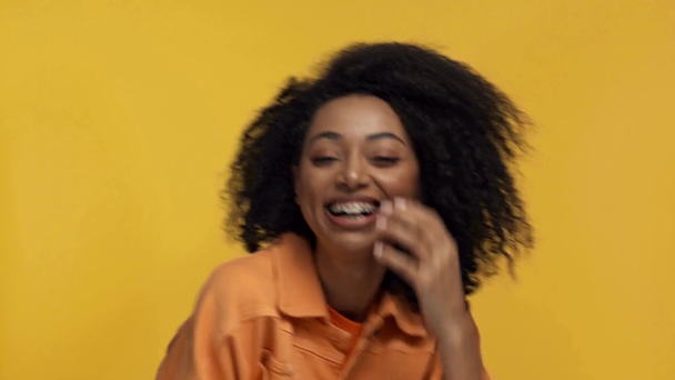 Afro-Amerikalı kadın, sarı üzerine izole bir şekilde gülümsüyor. - Video, Çekim