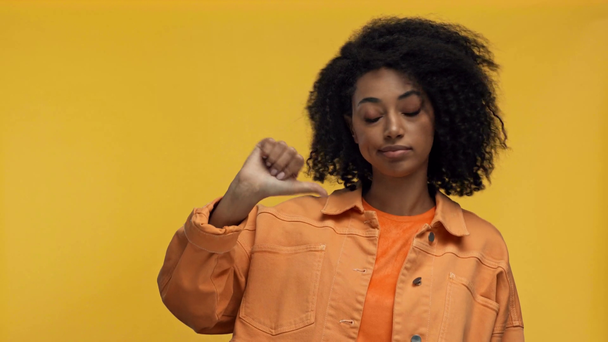 niezadowolona Afroamerykanka wskazująca palcem na żółtym - Materiał filmowy, wideo