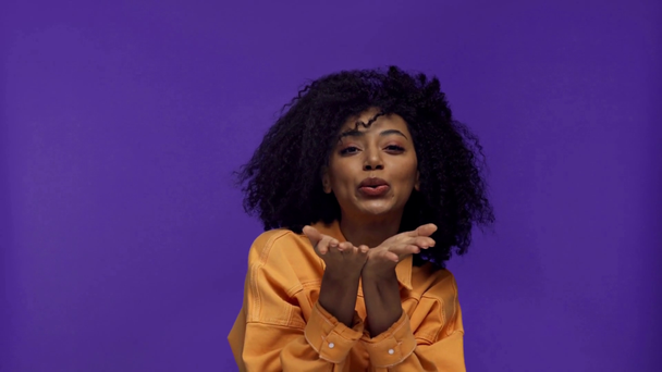 femme afro-américaine souriante montrant geste cardiaque isolé sur violet
  - Séquence, vidéo