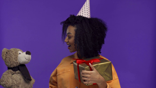souriant afro-américaine obtention cadeau et jouet isolé sur violet
  - Séquence, vidéo