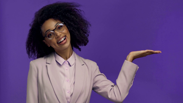 улыбающаяся африканская американская бизнесвумен, указывающая пальцем на фиолетовый
  - Кадры, видео