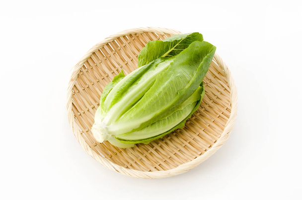 frischer grüner Römersalat auf Bambussieb auf weißem Hintergrund - Foto, Bild