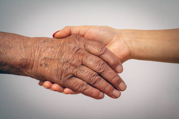alte und junge Frauen halten Händchen - Foto, Bild