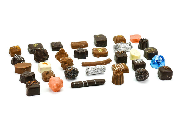 Deluxe előkelő csokoládé fajták, töltött karamell, krém, likőr, gyümölcsök és elszigetelt fehér alapon - Fotó, kép