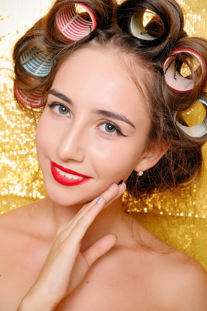 Beautiful girl in hair curlers isolated on gold - Fotoğraf, Görsel