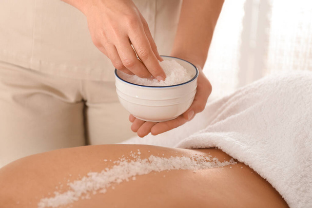 Young woman having body scrubbing procedure with sea salt in spa - Zdjęcie, obraz