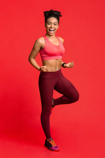 Happy fitness meisje oefenen over rode achtergrond - Foto, afbeelding