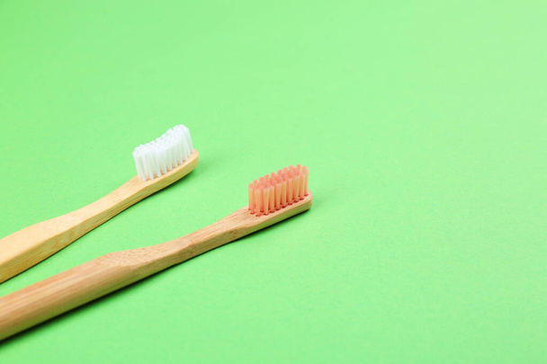 Natural bamboo toothbrushes on green background. Space for text - Valokuva, kuva