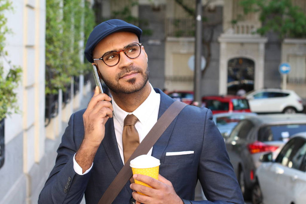 Un hombre de negocios étnico simpático que llama por teléfono al aire libre - Foto, imagen
