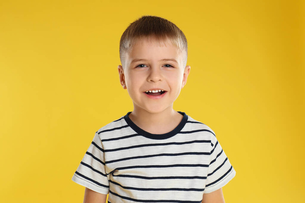 Πορτρέτο του ευτυχισμένου μικρού αγοριού σε κίτρινο φόντο - Φωτογραφία, εικόνα
