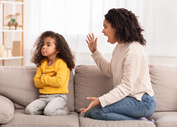 Wściekła matka krzyczy na córkę siedzącą na kanapie w domu - Zdjęcie, obraz