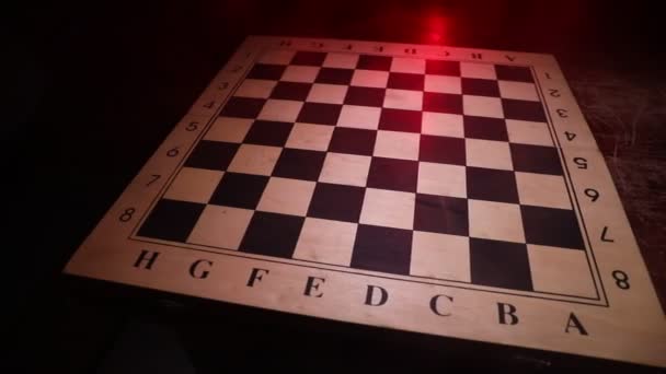 Hra na šachovnici s obchodními nápady a konkurencí. Šachové postavy na tmavém pozadí s kouřem a mlhou. Selektivní zaměření - Záběry, video