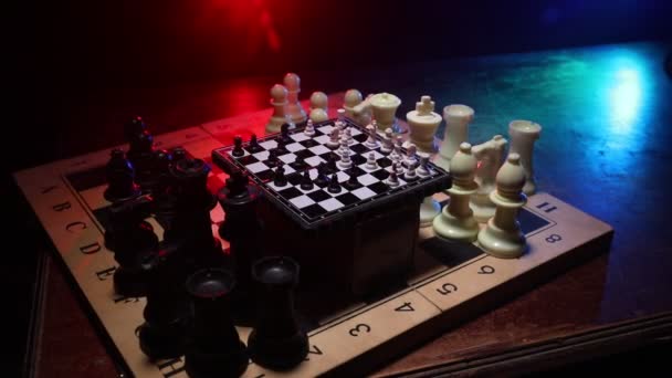 Schaakbord spel concept van Business ideeën en competitie. Schaak figuren op een donkere achtergrond met rook en mist. Selectieve focus - Video